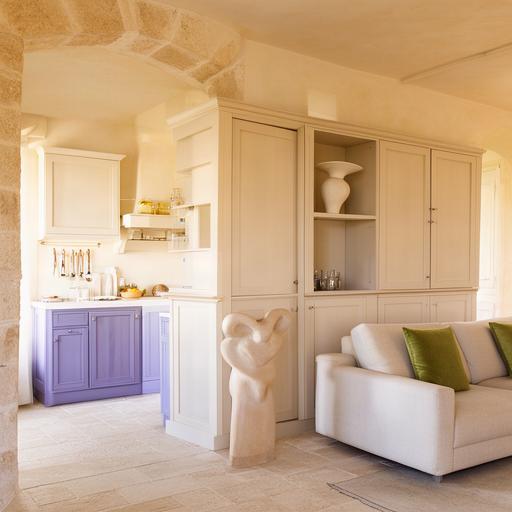 Zona giorno pugliese con mobile contenitore coordinato alla cucina e pareti chiare