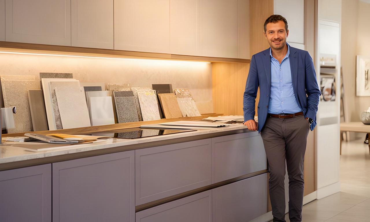 Consulente accanto a una cucina italiana su misura nello showroom di Ruvo di Puglia